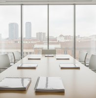 Sala de reuniones con informes encuadernados sobre la mesa